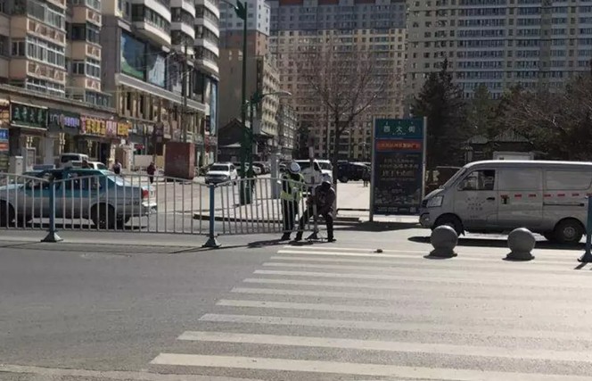 海拉尔一小伙骑车刮倒护栏 热心大爷帮女交警的暖心一幕